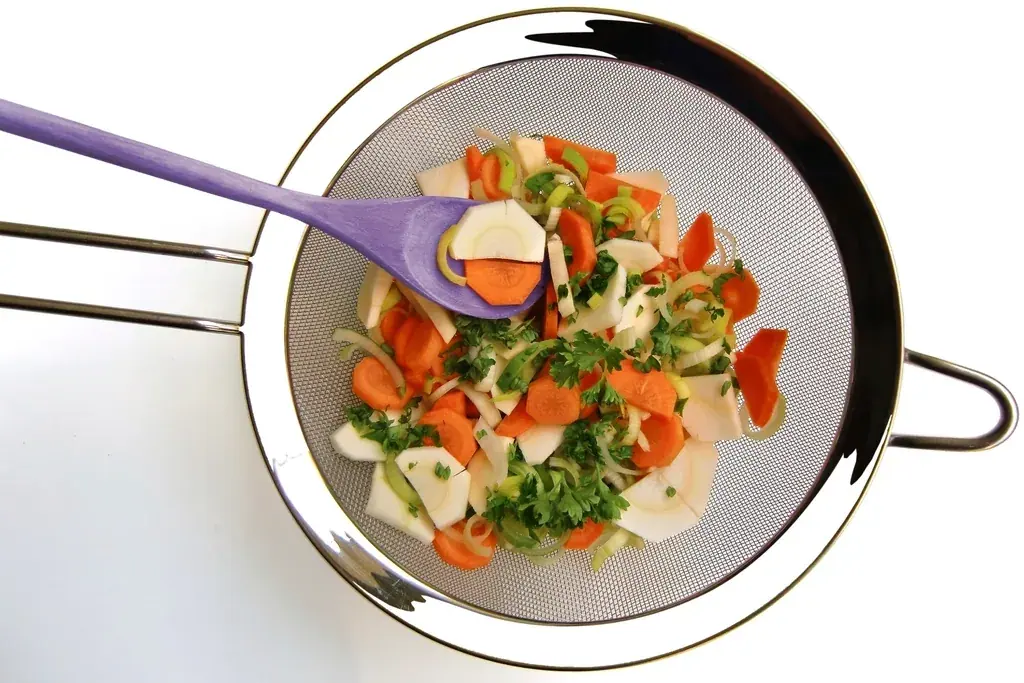 Sliced carrots and fennel in a kitchen sieve